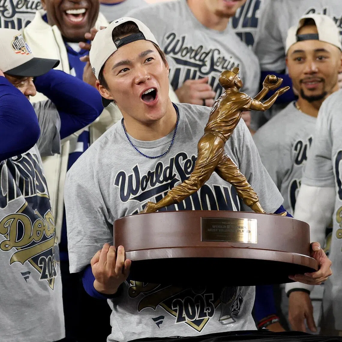 TORONTO, ONTARIO - NOVEMBER 02: Yoshinobu Yamamoto #18 of the Los Angeles Dodgers raises the Willie Mays World Series Most Valuable Player Award after defeating the Toronto Blue Jays 5-4 in game seven of the 2025 World Series at Rogers Center on November 02, 2025 in Toronto, Ontario.   Emilee Chinn/Getty Images/AFP (Photo by Emilee Chinn / GETTY IMAGES NORTH AMERICA / Getty Images via AFP)
