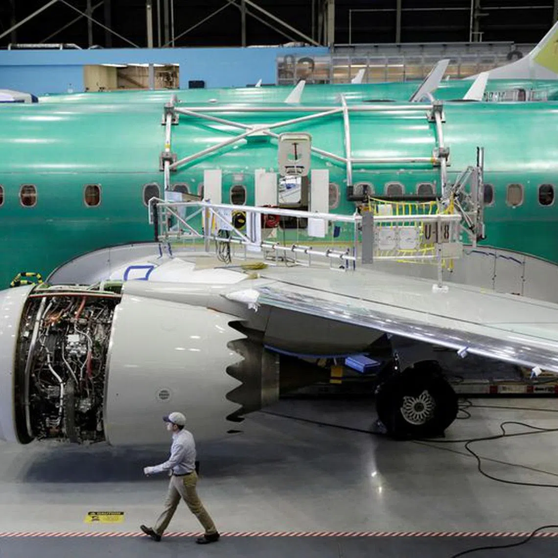 FILE PHOTO: A worker walks past Boeing's new 737 MAX-9 under construction at their production facility in Renton, Washington, U.S., February 13, 2017. Picture taken February 13, 2017. REUTERS/Jason Redmond/File Photo