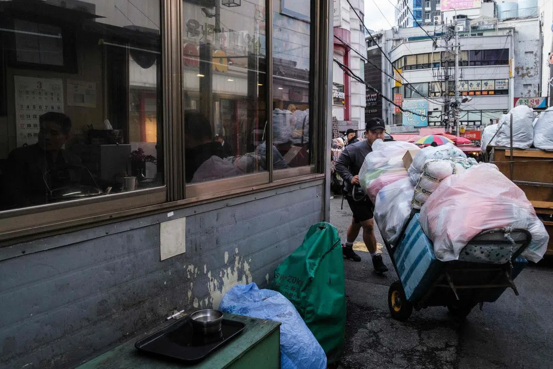 A worker pushes a trolley loaded with goods past an office at Namdaemun Market in Seoul on March 26.