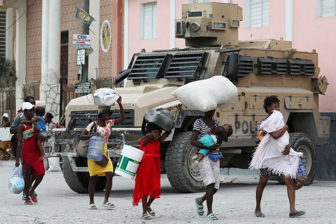 FILE PHOTO: Residents carry belongings as they leave their homes due to gang violence, in the Pernier section of Port-au-Prince, Haiti January 30, 2024. REUTERS/Ralph Tedy Erol