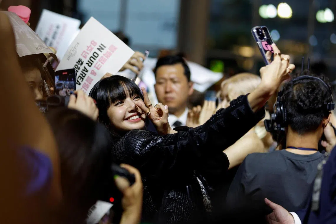 Lisa from the K-pop girl group Blackpink takes selfies with her fans at the premiere of their world tour film Born Pink, marking the group's eighth anniversary, in Seoul, on Aug 9.