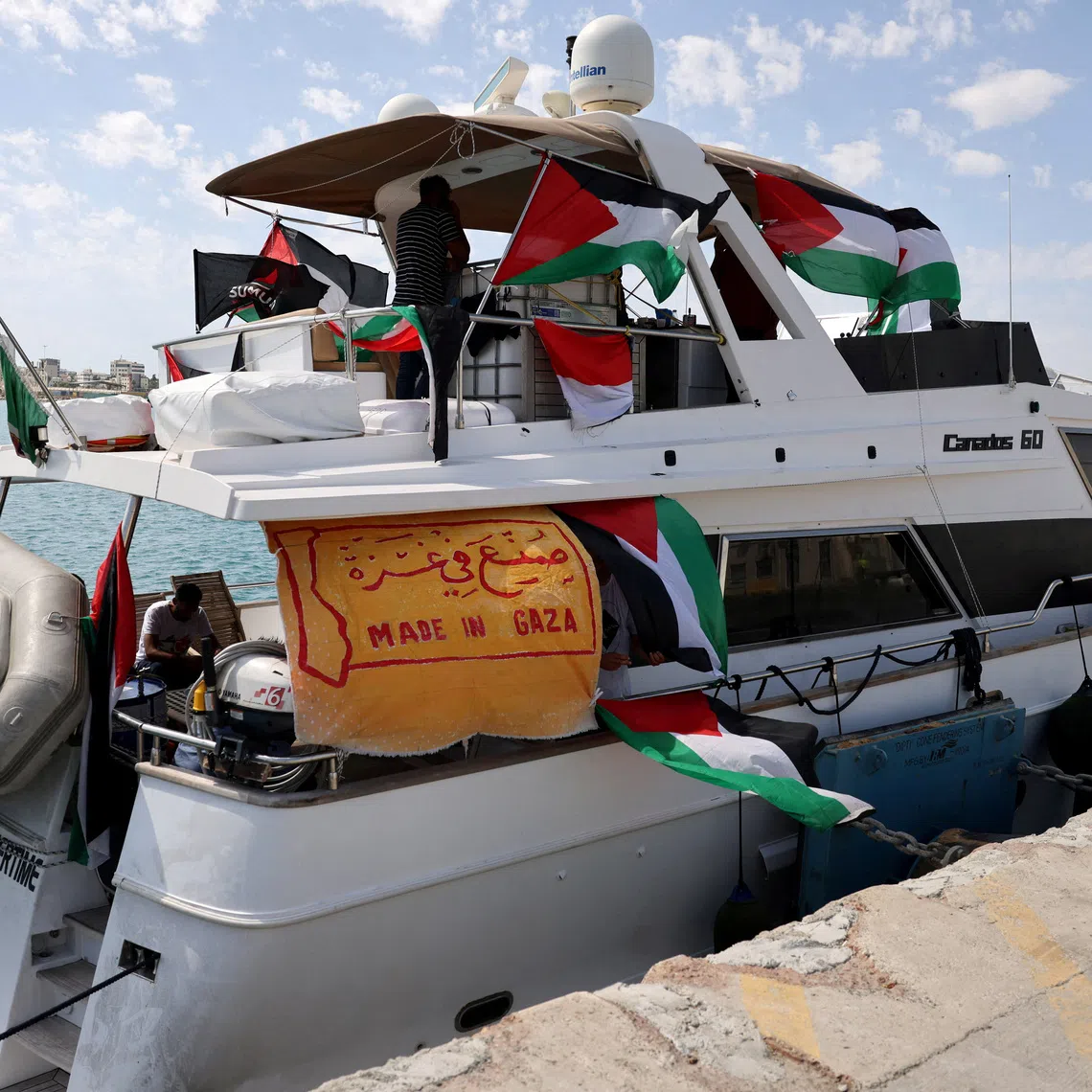 FILE PHOTO: People gather on a boat from a flotilla that had been carrying aid to Gaza until it was intercepted by Israel, docked in the port of Larnaca, Cyprus October 3, 2025. REUTERS/Yiannis Kourtoglou/File Photo