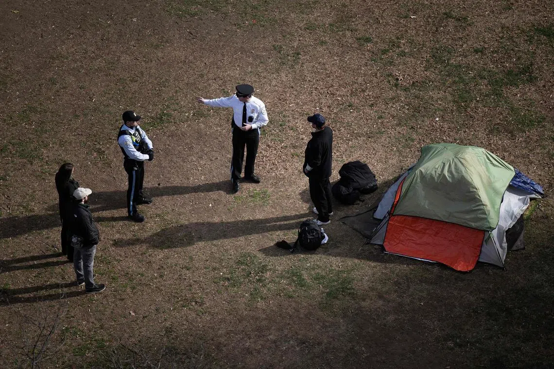 (FILES) Park Police talk to a man who refused to leave after members of the US National Park Service cleared a homeless encampment from McPherson Square, two blocks from the White House in Washington, DC, on February 15, 2023. President Donald Trump said on August 10, 2025, that homeless people must be moved "far" from Washington, after days of musing about taking federal control of the US capital where he has falsely suggested crime is rising. The Republican billionaire has announced a press conference for August 11 in which he is expected to reveal his plans for Washington -- which is run by the locally elected government of the District of Columbia under congressional oversight. (Photo by Brendan Smialowski / AFP)
