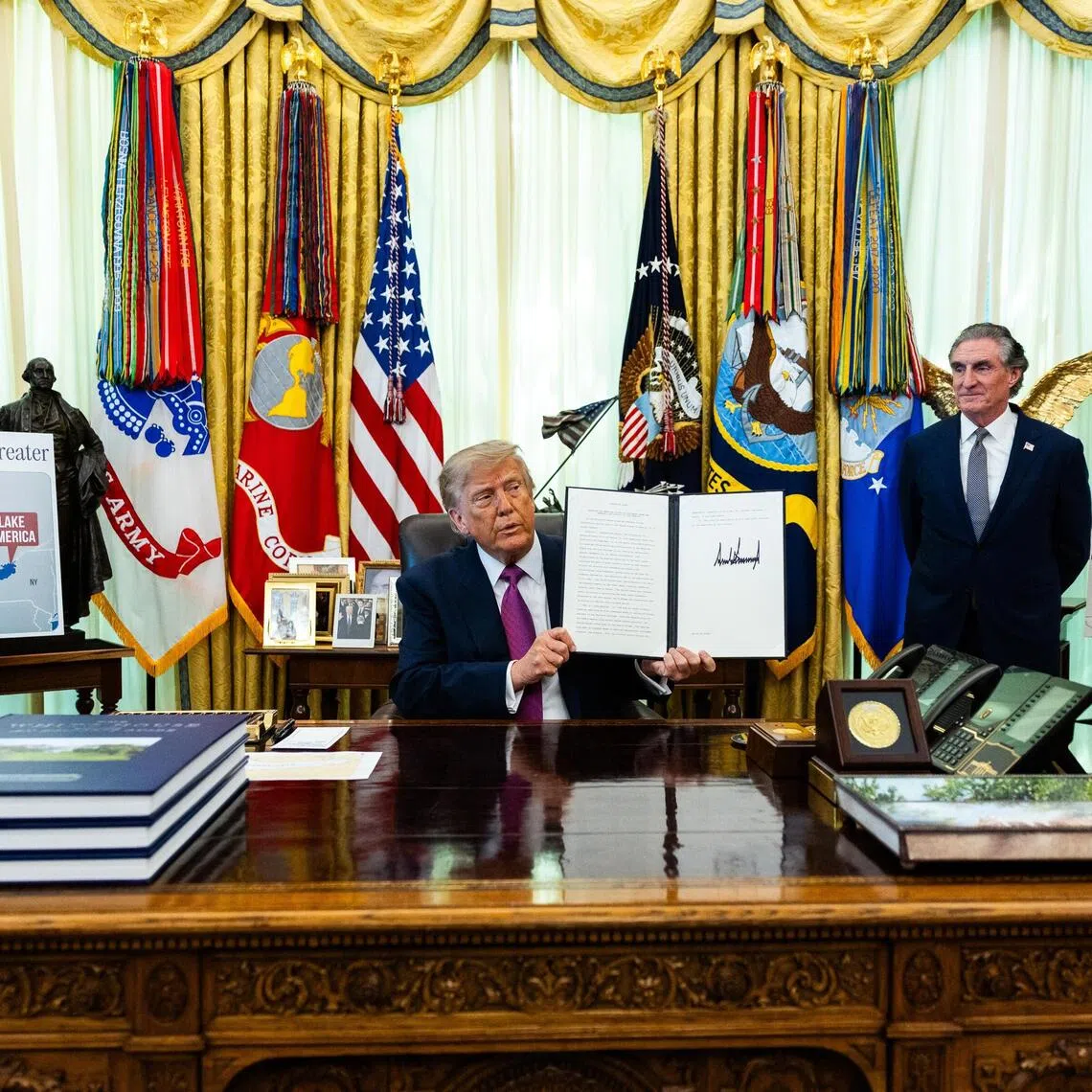 US President Donald Trump holding up an executive order he signed on Aug 27, to change the name of Lake Ontario to Lake America.