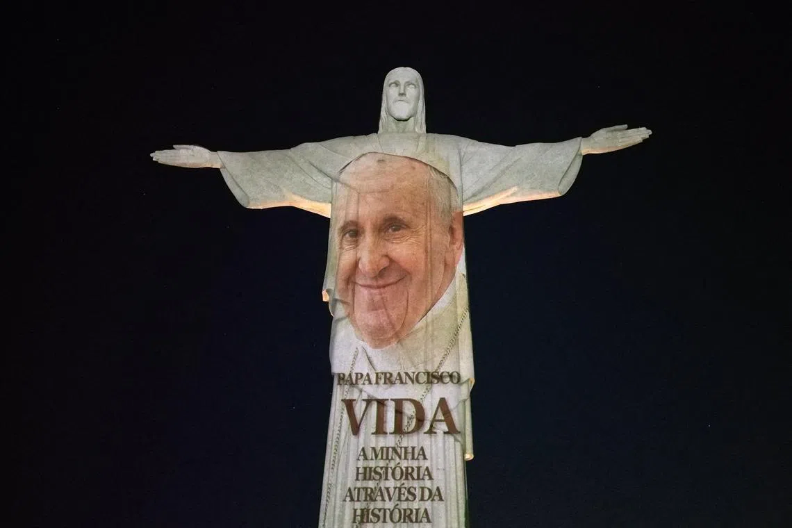 A picture of Pope Francis is projected on the Christ The Redeemer statue to launch his new book in Rio de Janeiro.