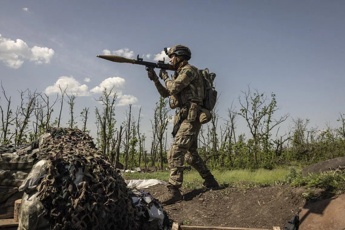 A Ukrainian soldier prepares to fire a rocket-propelled grenade towards Russian positions, in Ukraine's eastern Donetsk region.