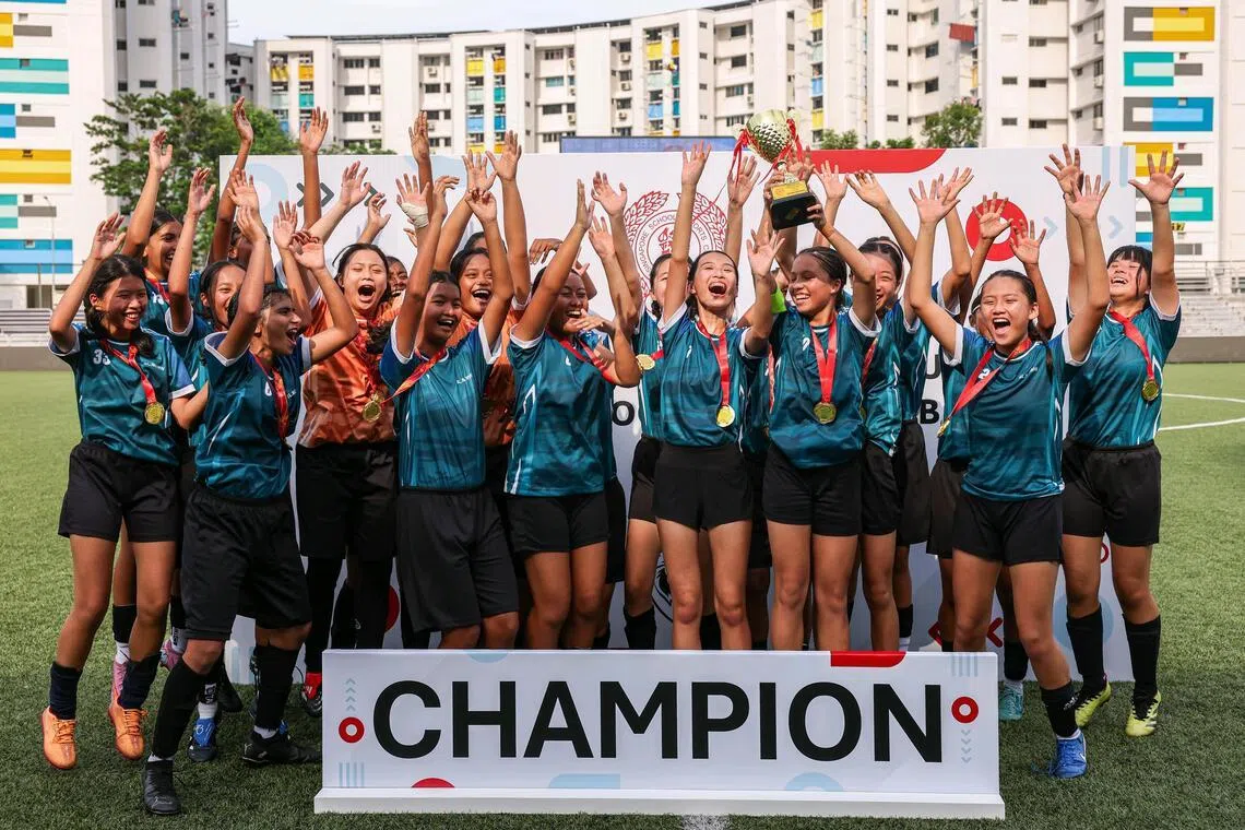 CBP W3 Combined team players celebrating with the champion's trophy after defeating Meridian Secondary School in the B Division Girls? League 1 football final at Jurong East Stadium on April 15, 2026. ST PHOTO: BRIAN TEO