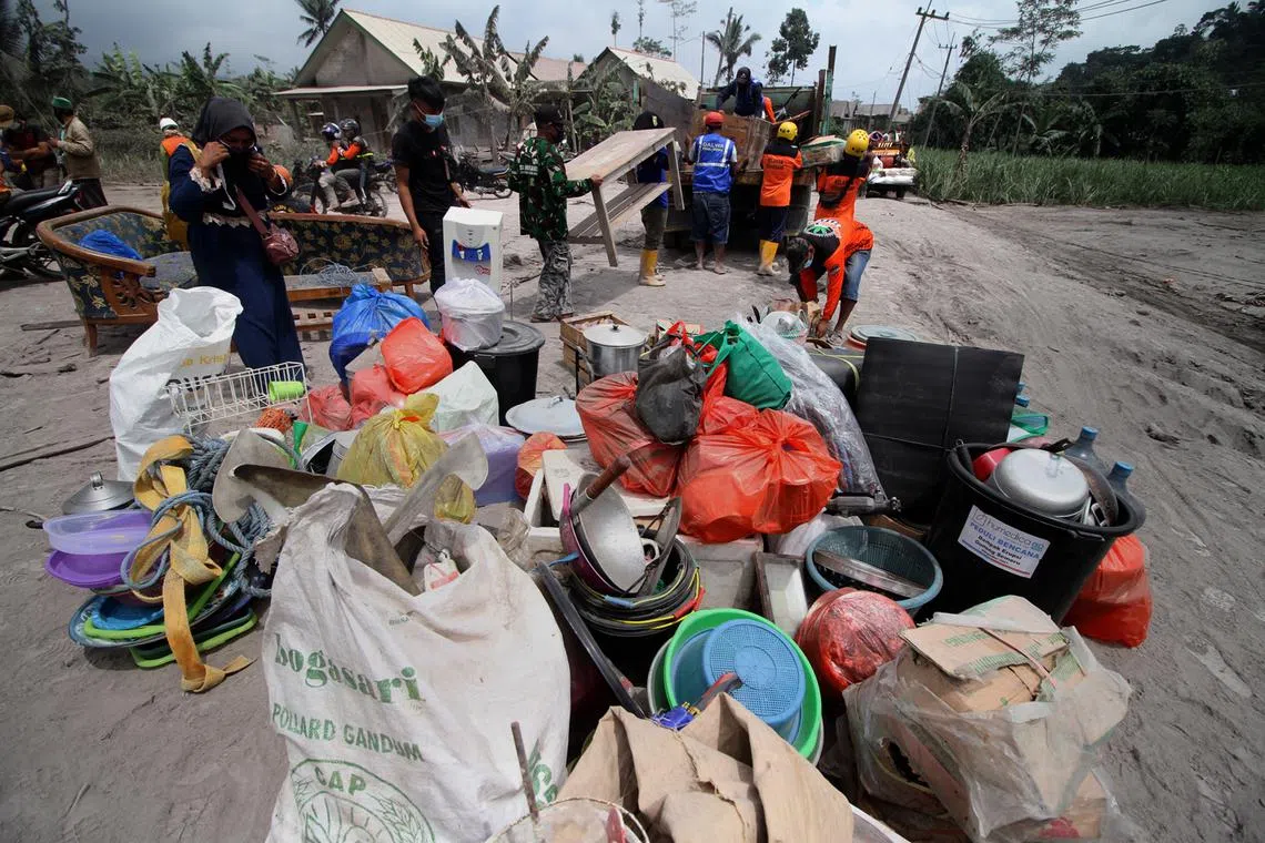 Villagers load their belongings onto a truck as they evacuated from their houses affected by the volcanic materials from the eruption of Mount Semeru at Kajar Kuning village in Lumajang, East Java, Indonesia, Dec 5, 2022.  