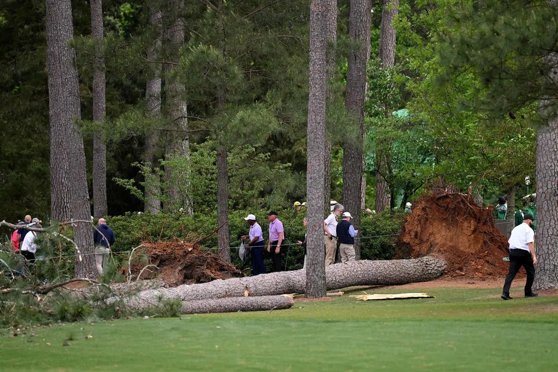 Course officials look over fallen trees on the 17th hole during the second round of the 2023 Masters Tournament.
