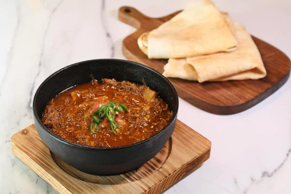 Fahsah, a dish of shredded mutton gravy, comes with Yemeni pita on the side.