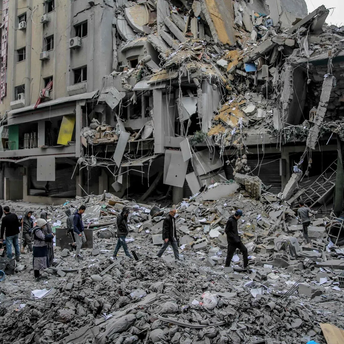 TOPSHOT - Palestinians walk amid the rubble of houses destroyed by Israeli bombardment in Gaza City on March 3, 2024, amid the ongoing conflict between Israel and the Hamas movement. (Photo by AFP)