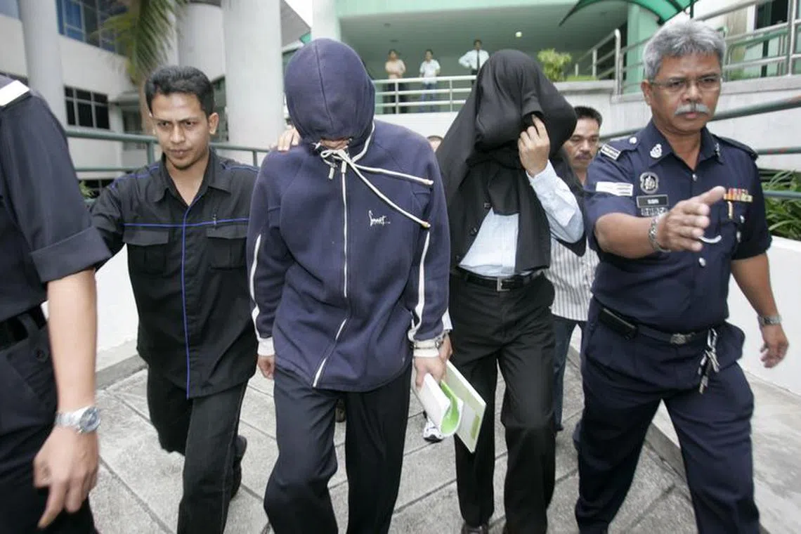 FILE PHOTO: Policemen Azilah Hadri (2nd L) and Sirul Azhar Umar (2nd R) arrive at the courthouse in Shah Alam outside Kuala Lumpur January 15, 2009. Hadri and Umar on Thursday began their defence after being accused of murdering Mongolian Altantuya Shaariibuu. REUTERS/Bazuki Muhammad/File Photo