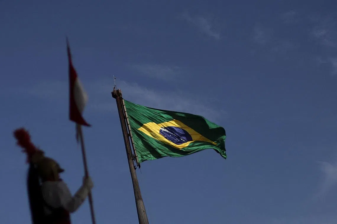 A soldier of the presidential guard stands at the Planalto Palace as the Brazilian flag flutters in the background, in Brasilia, Brazil July 31, 2025. REUTERS/Adriano Machado