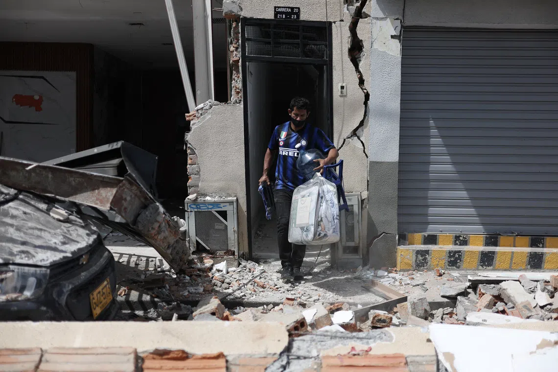 A man retrieves belongings from a damaged building.