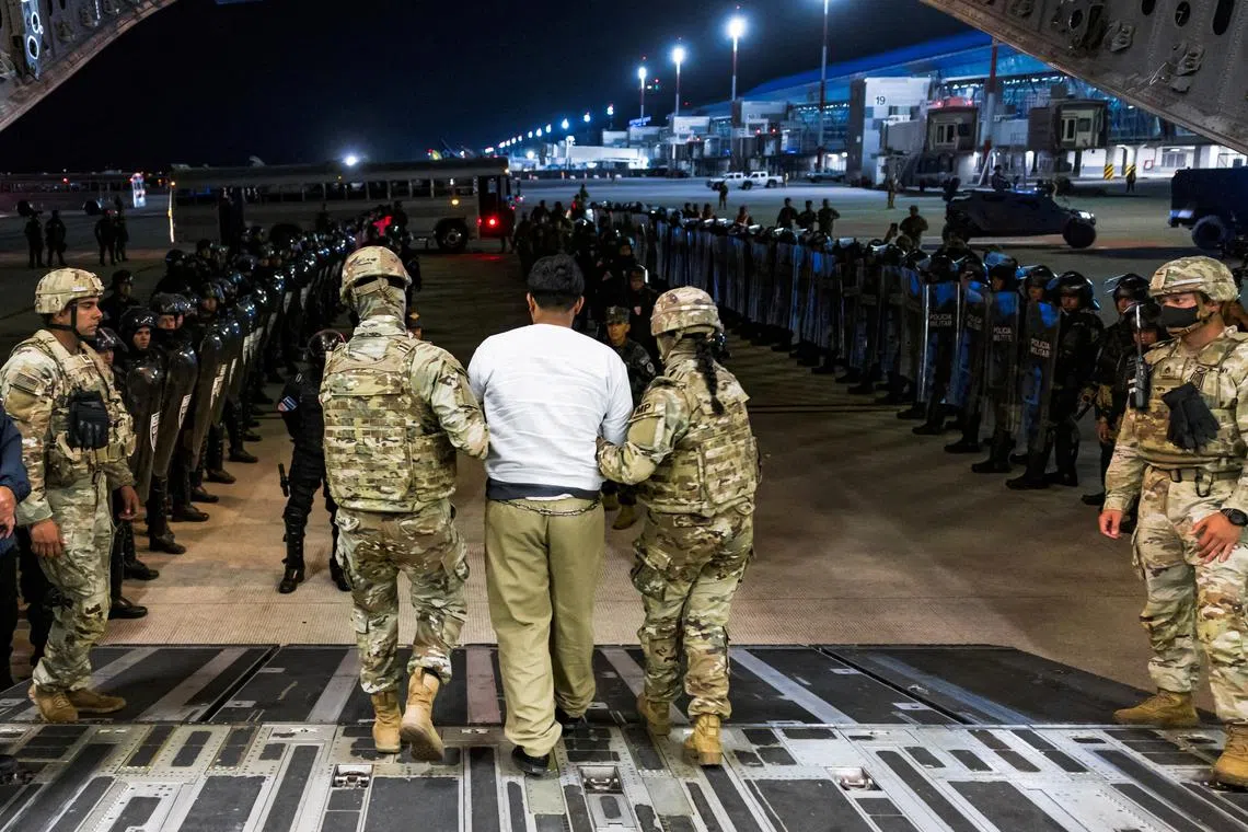 FILE PHOTO: U.S. military personnel escort an alleged gang member who was deported by the U.S. along with others the U.S. alleges are members of the Venezuelan gang Tren de Aragua and the MS-13 gang to be imprisoned in the Terrorism Confinement Center (CECOT) prison, at the El Salvador International Airport in San Luis Talpa, El Salvador April 12, 2025. Secretaria de Prensa de la Presidencia/Handout via REUTERS/File Photo