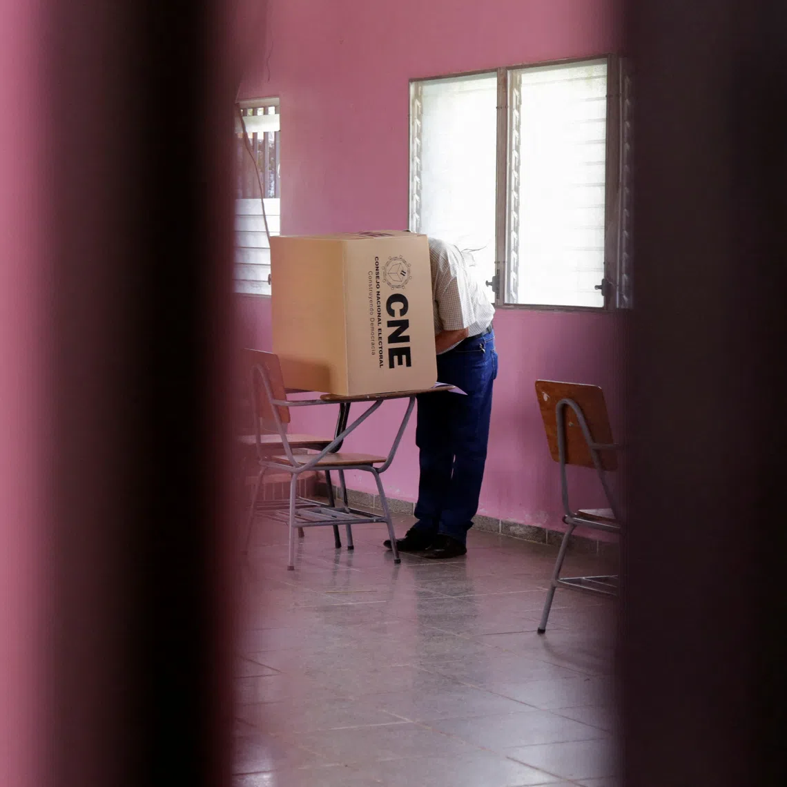 A man prepares his vote before casting his ballot, a week late in a special election, after the local governing party kept polls closed on election day, amid accusations of sabotage and fraud in a presidential race still too close to call as counting continues, in San Antonio de Flores, Honduras, December 7, 2025. REUTERS/Leonel Estrada