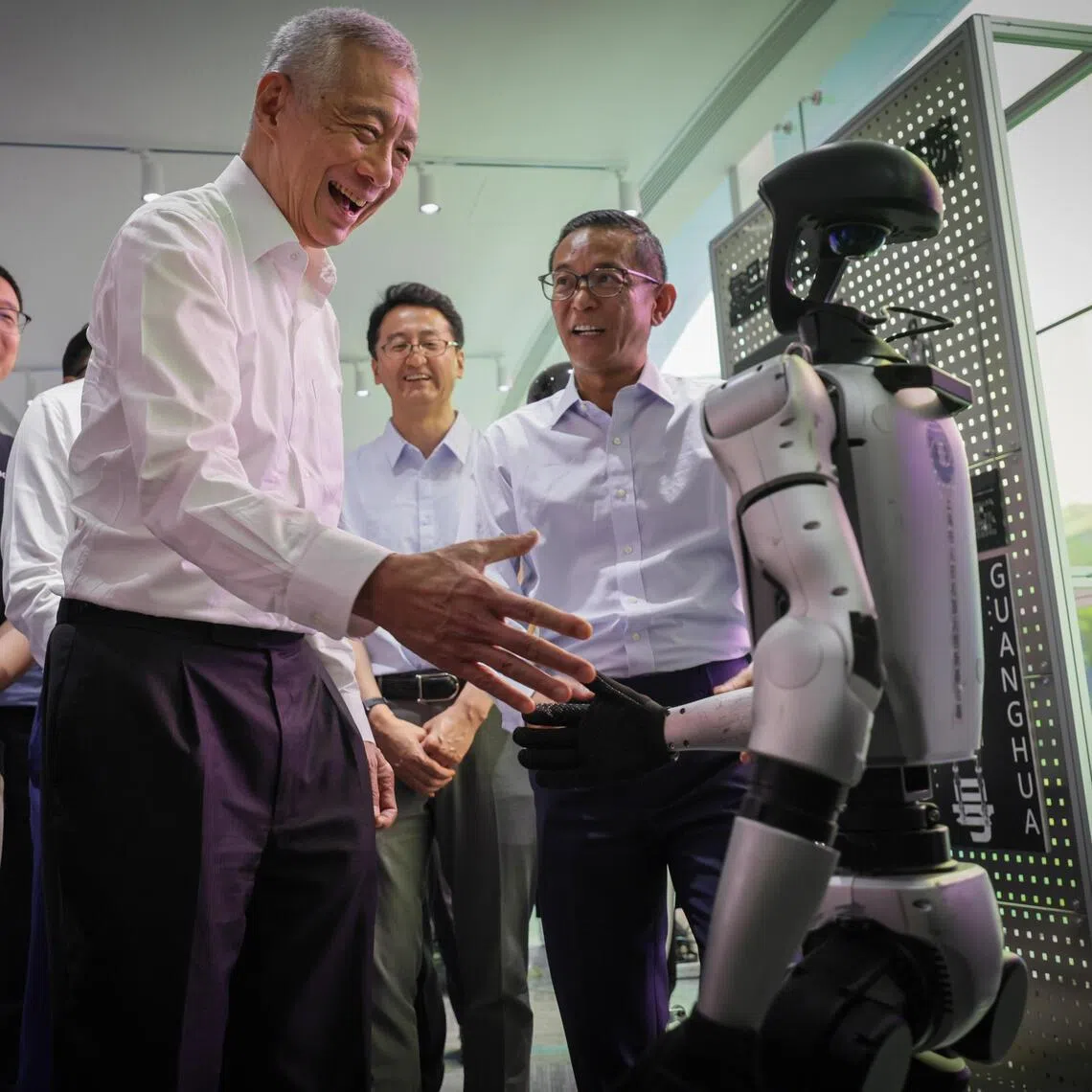 Senior Minister Lee Hsien Loong shaking hand with a robot when he toured the Shanghai Municipal Humanoid Robot Innovation Incubator on May 21.