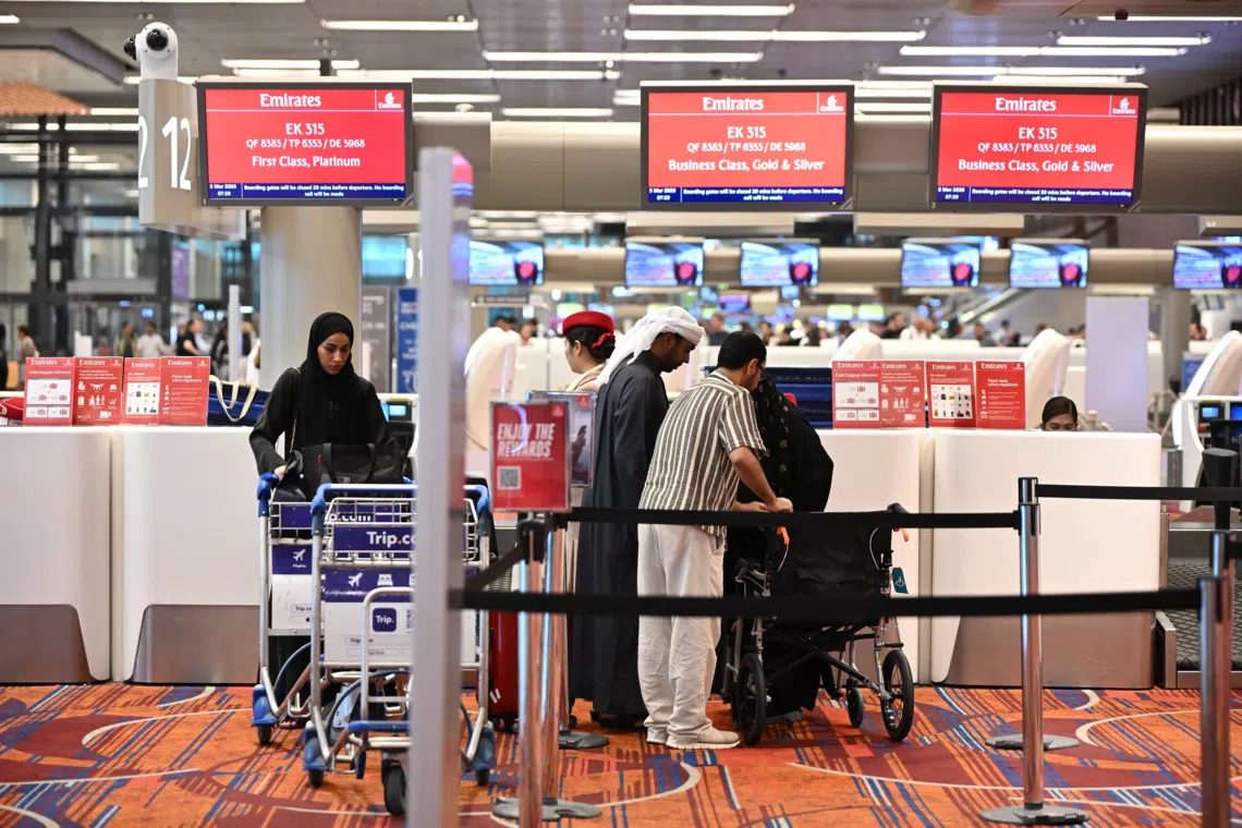 Passengers checking in for Flight EK315 to Dubai at Changi Airport Terminal 1 on March 5.