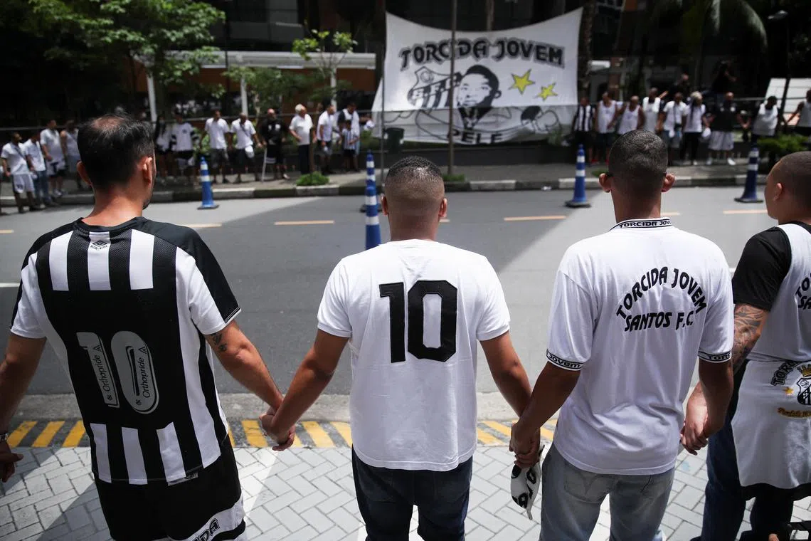 Fans holding hands during a vigil in front of the Albert Einstein Hospital where Brazilian football legend Pele is hospitalised in Sao Paulo, Brazil, on Dec 4.