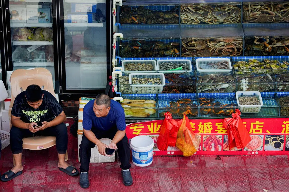 Vendors wait for customers at a seafood market in Shanghai, China August 25, 2023. REUTERS/Aly Song