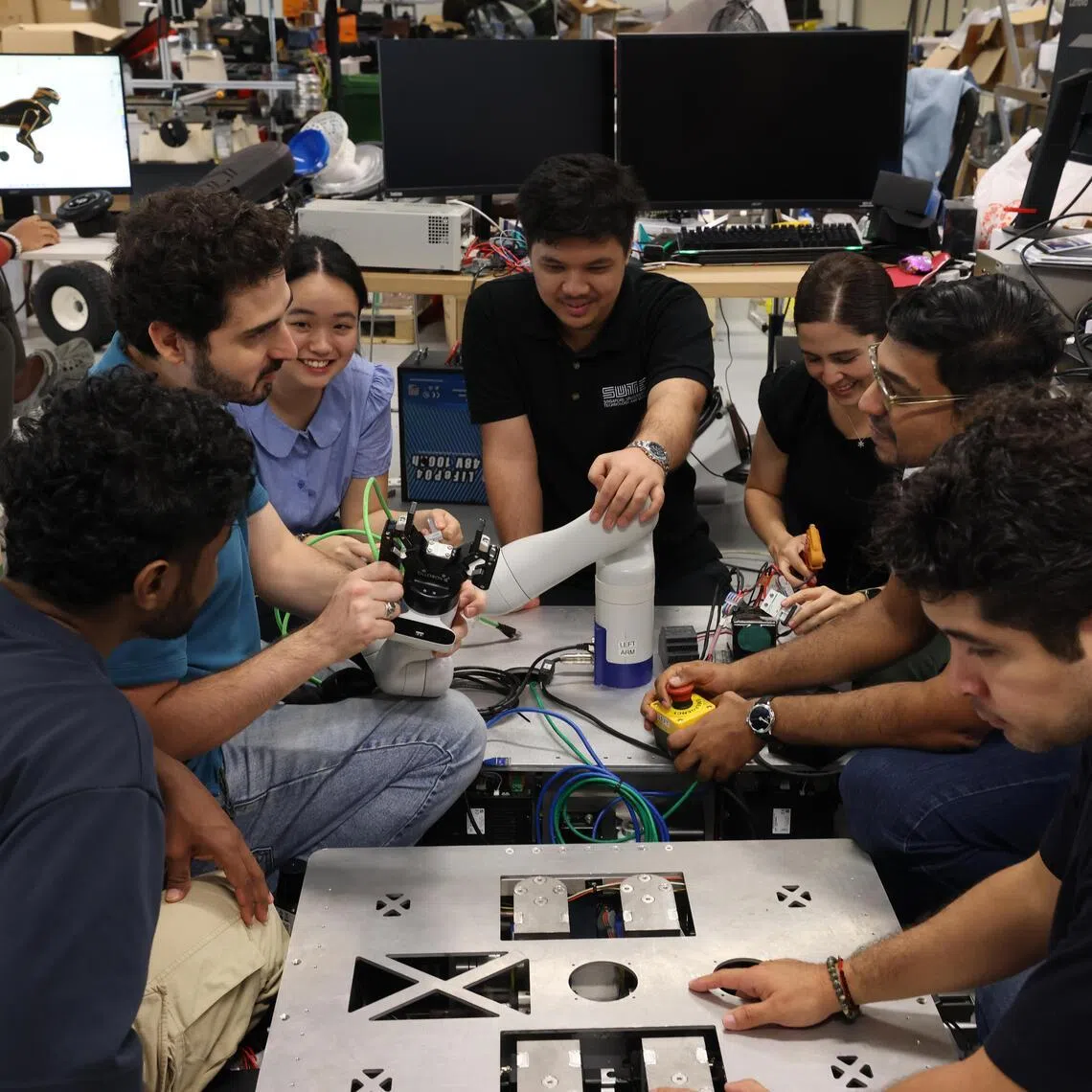 The research team from SUTD working together on the wasp, a nested, reconfigurable, logistics robot.