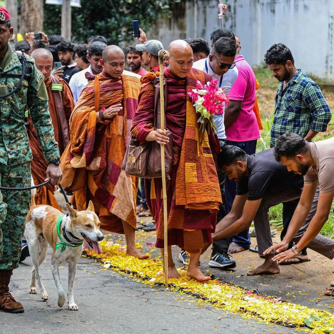 Vietnamese Buddhist monk Bhikkhu Pannakara (centre) accompanied by Sri Lankan army commandos walks with his pet dog Aloka, a stray rescued from India, at the start of the 'Walk For Peace' pilgrimage, on April 22.