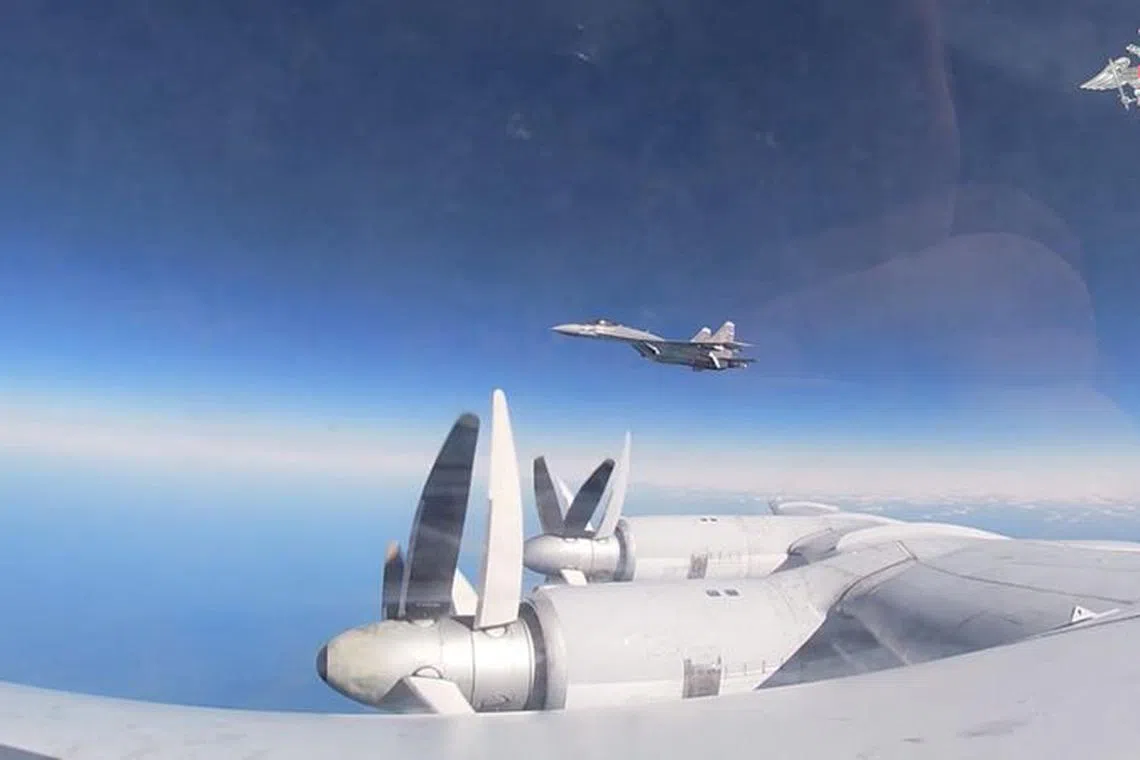 A still image from video, released by the Russian Defence Ministry, shows what it said to be Russia's Tu-95MS strategic bomber escorted by a Sukhoi Su-35S jet fighter during a seven-hour flight over the Sea of Japan, in this image taken from video released October 17, 2023. Russian Defence Ministry/Handout via REUTERS