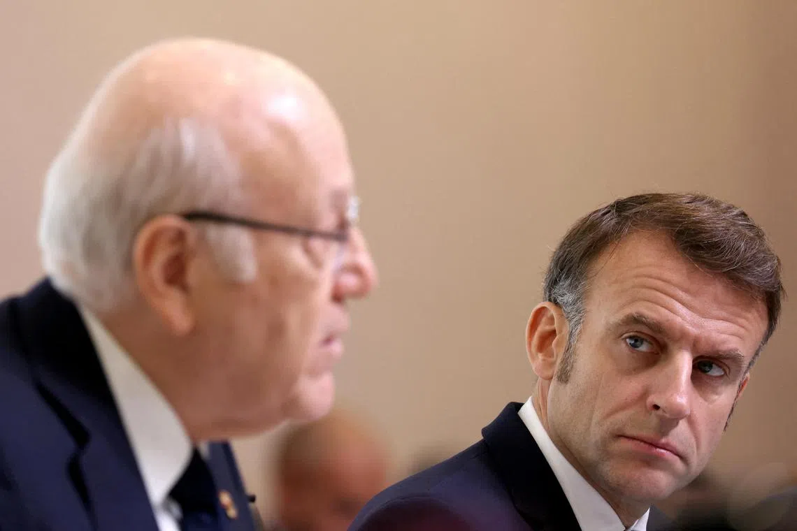 France's President Emmanuel Macron (right) looks on as Lebanon's Prime Minister Najib Mikati addresses an international summit in Paris.