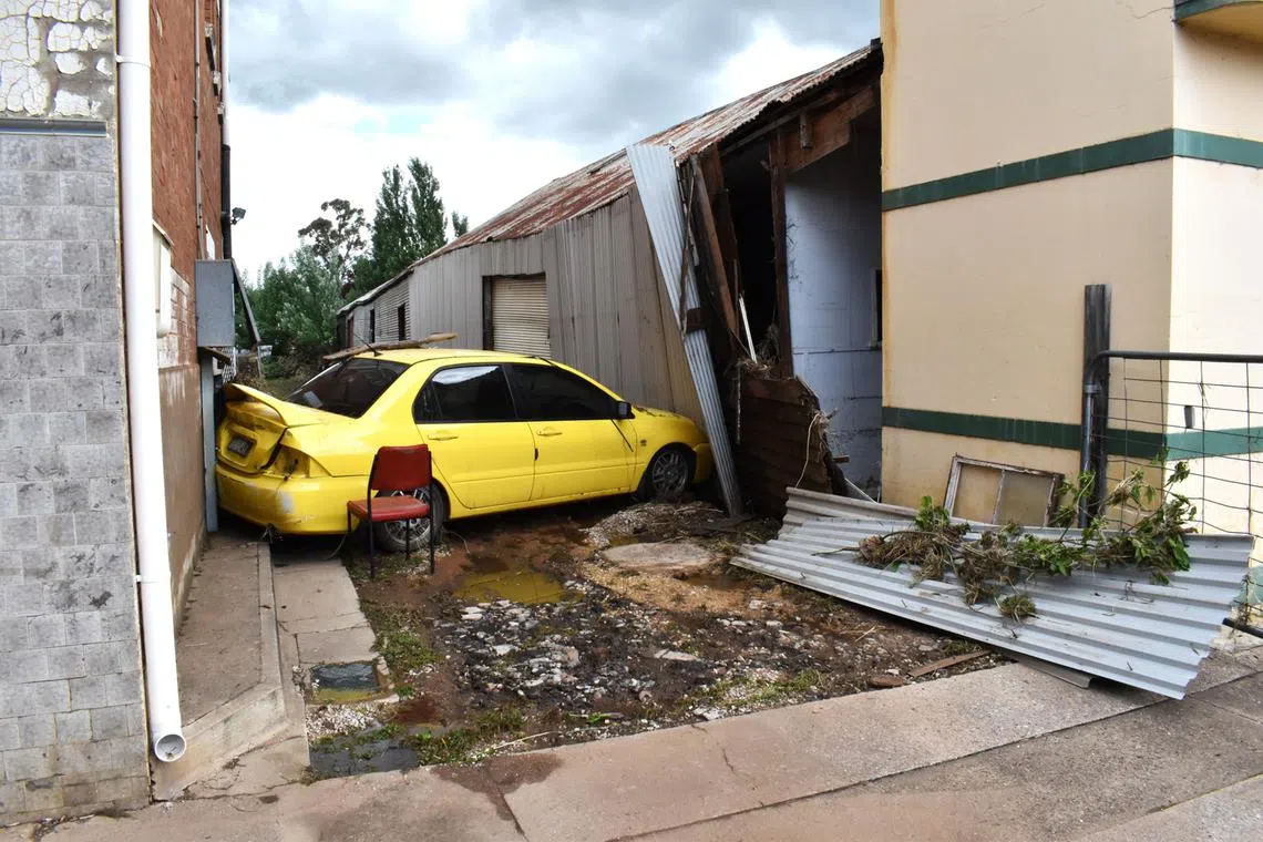 A car wedged in a laneway after being swept up in the aftermath of a flood in Molong, New South Wales, Australia, Nov 14, 2022. 