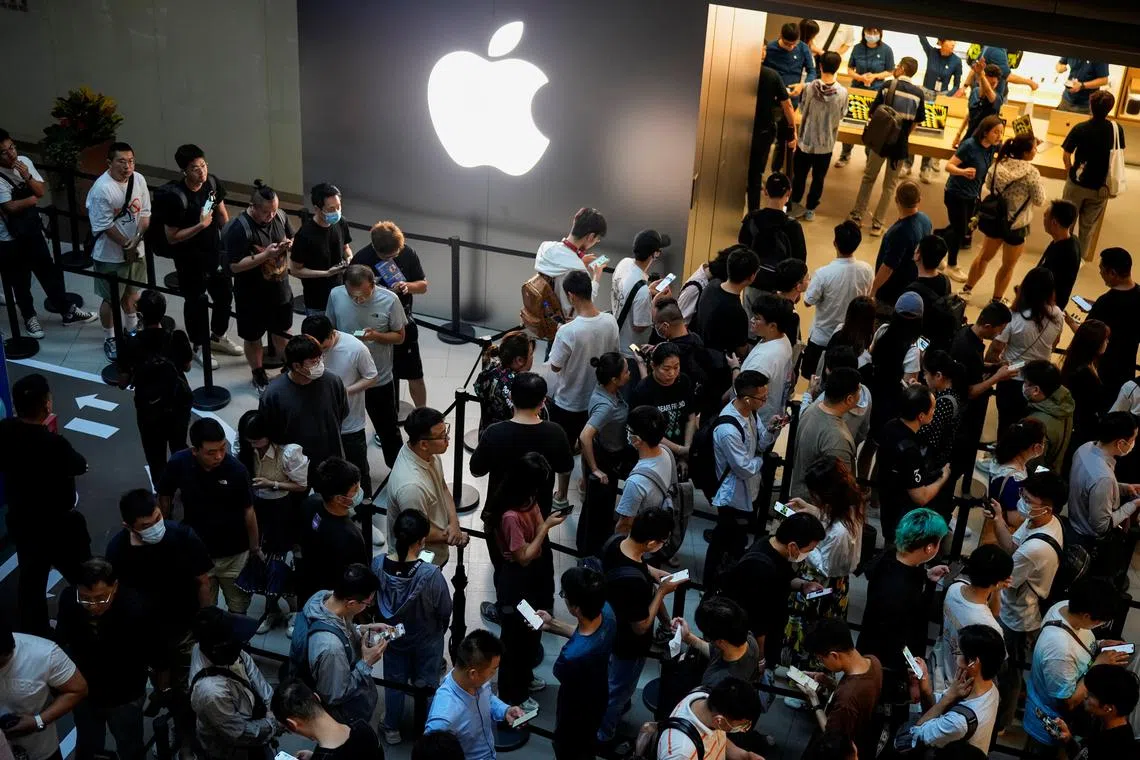 People line up as they wait at an Apple Store as Apple’s new iPhone 15 officially goes on sale across China, in Shanghai.