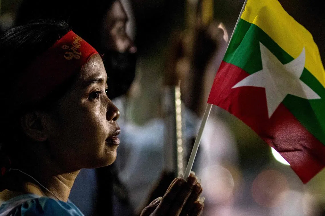 A woman attends a rally by Myanmar migrants living in Thailand outside the United Nations ESCAP building in Bangkok on March 5, 2021.
