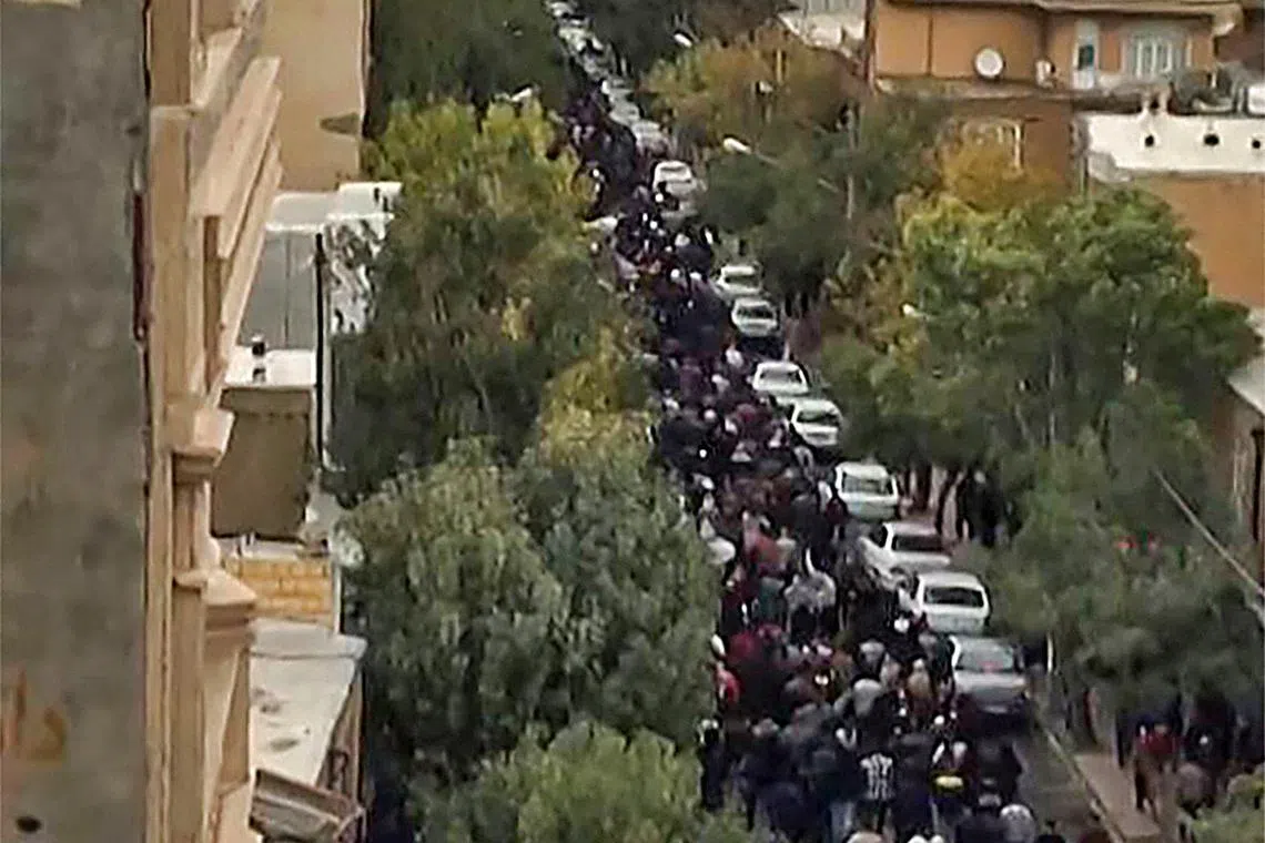 This image grab from a UGC video posted on Oct 27, 2022, shows protesters marching on a street in Iran's Kurdish city of Mahabad.