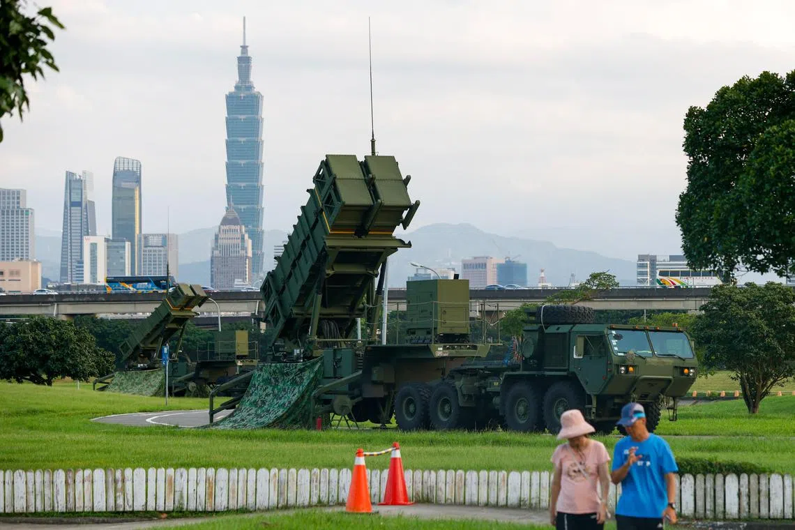 epa12239193 People walk past Taiwan military Patriot air defense system deployed at a park as part of the annual Han Kuang military exercises, in Taipei, Taiwan, on July 15, 2025.