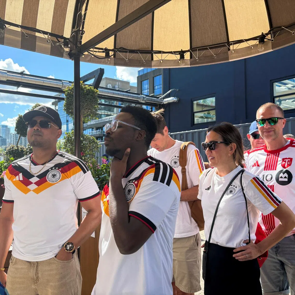 German fans queue outside a downtown pub for a fan party in Toronto.