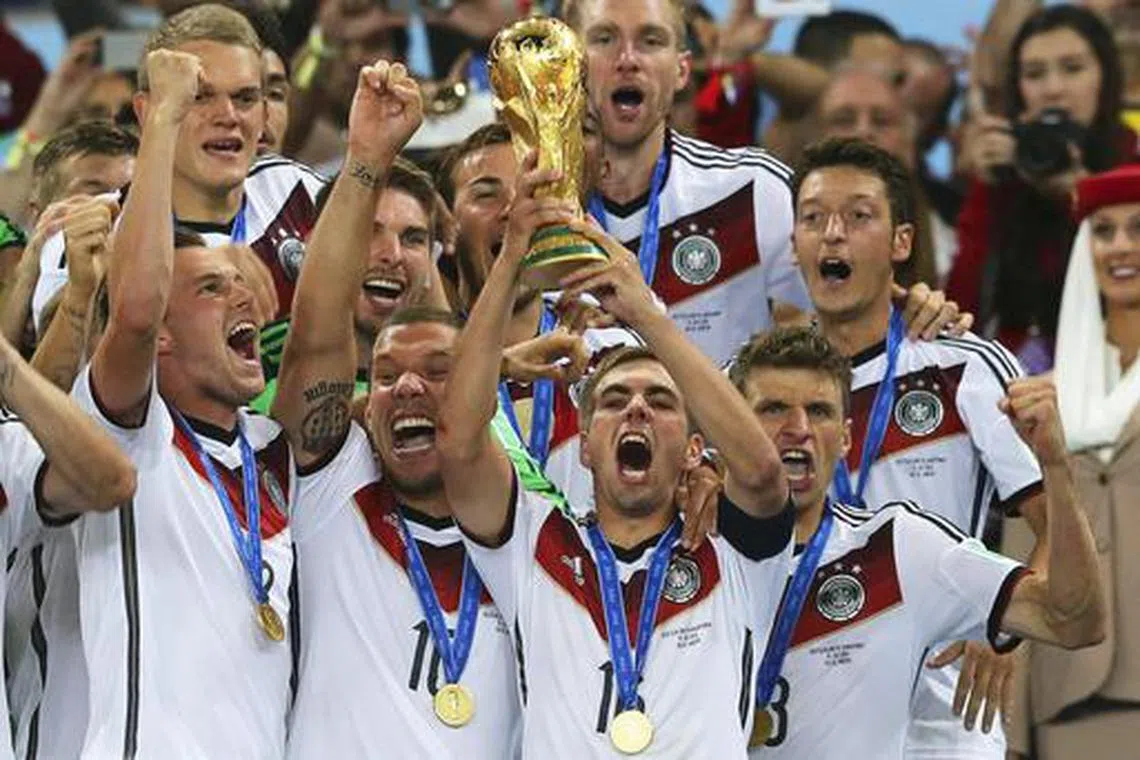 Philipp Lahm lifting the World Cup with his teammates cheering in 2014, after Germany defeated Argentina 1-0 in the final.