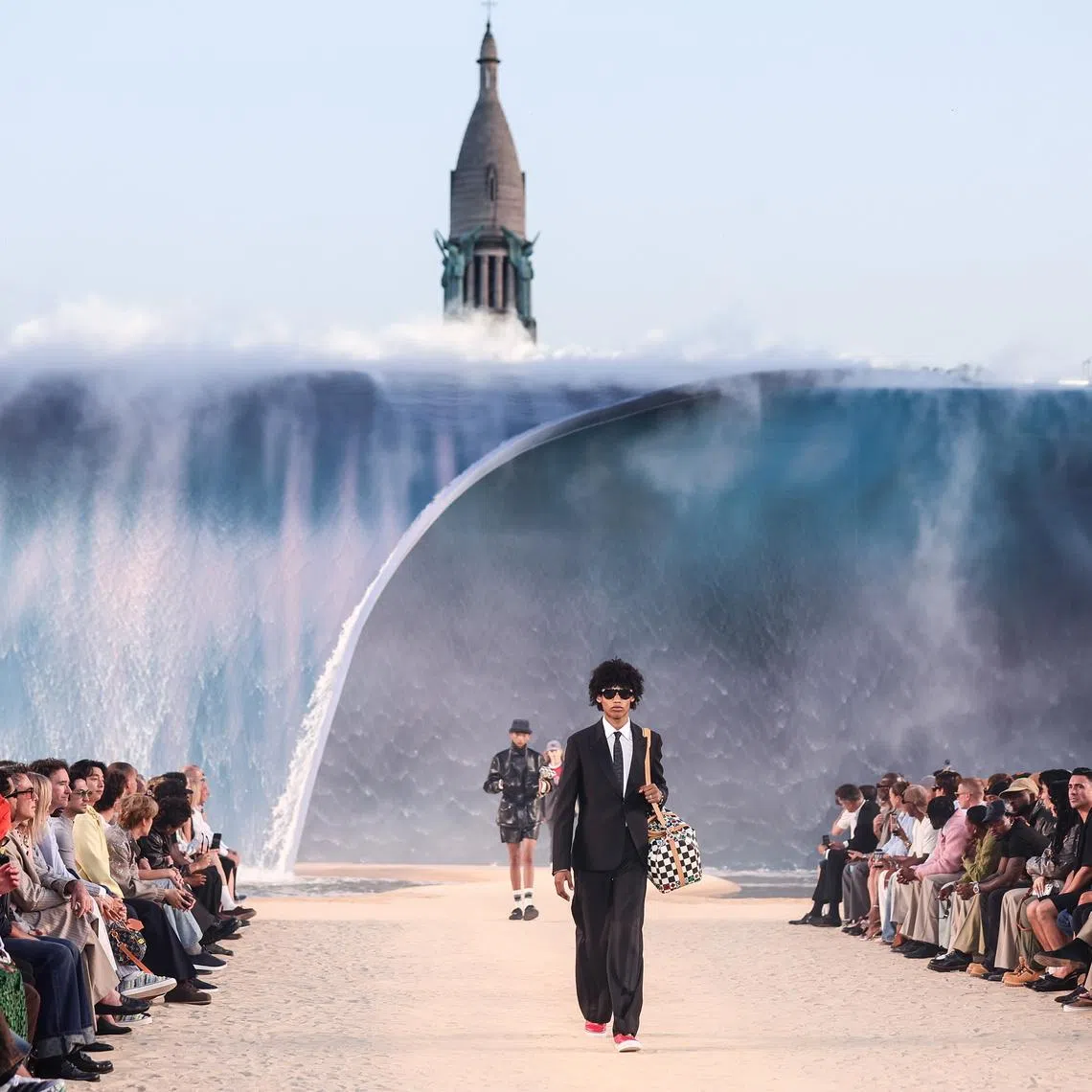 Models wore an eclectic mix of denim, hoodies and flashy jackets as they walked over sand.