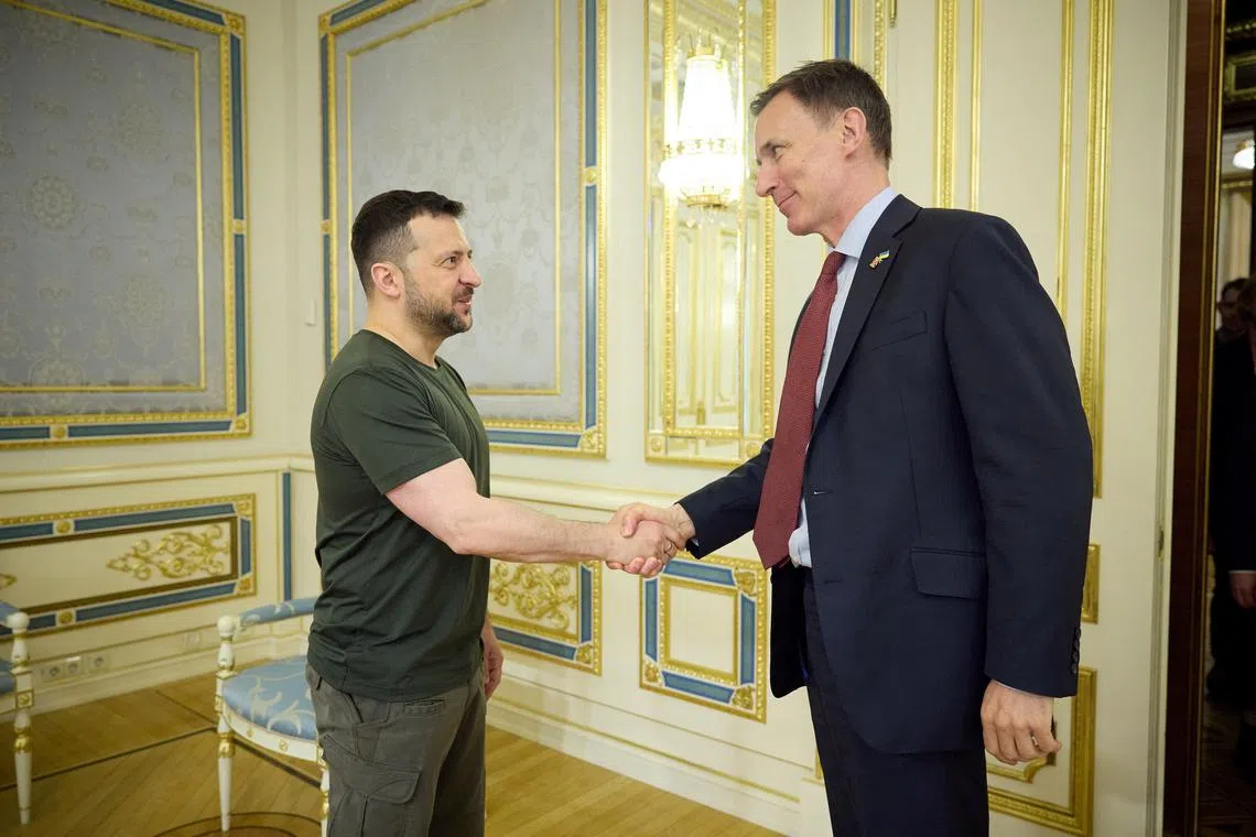Ukraine's President Volodymyr Zelenskiy and British Chancellor of the Exchequer Jeremy Hunt shake hands as they attend a joint meeting, amid Russia's attack on Ukraine, in Kyiv, Ukraine in this handout picture released April 25, 2024. Ukrainian Presidential Press Service/Handout via REUTERS