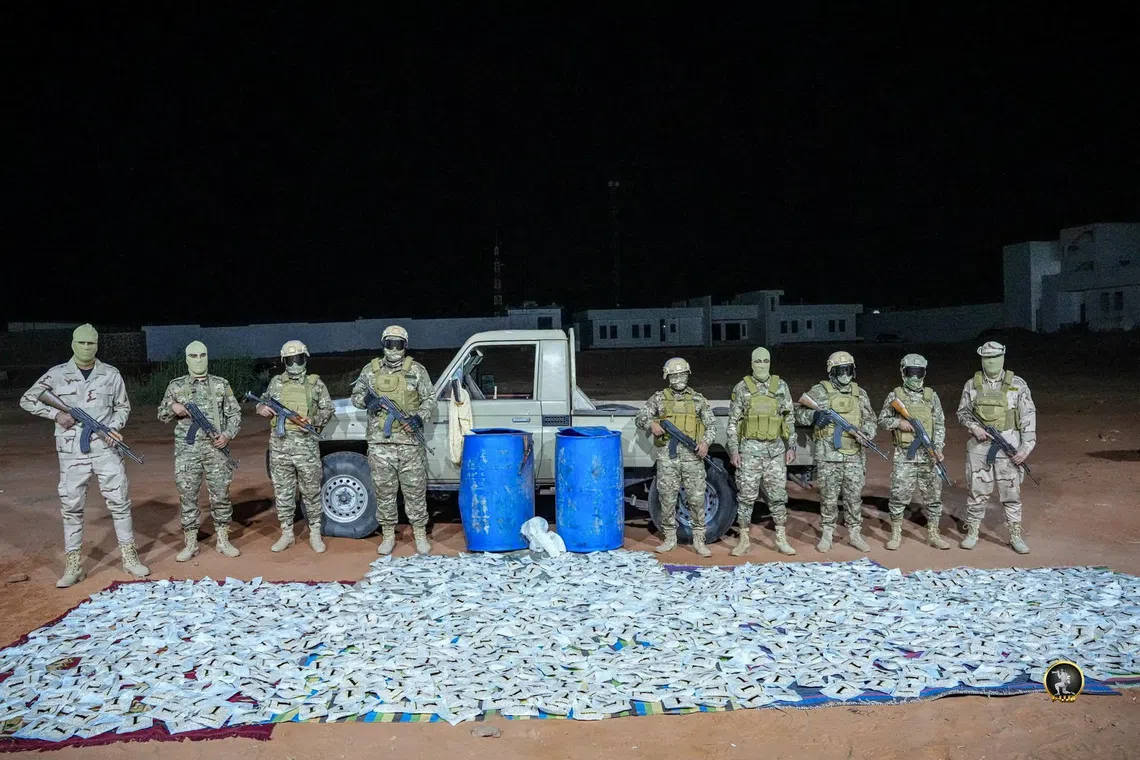 Members of the security forces stand next to a vehicle and seized narcotic pills after a security operation conducted by the Subul Al-Salam Infantry Brigade in a location given as Kufra, Libya, according to the military, in this photo released October 9, 2026. Libyan National Army/Handout via REUTERS