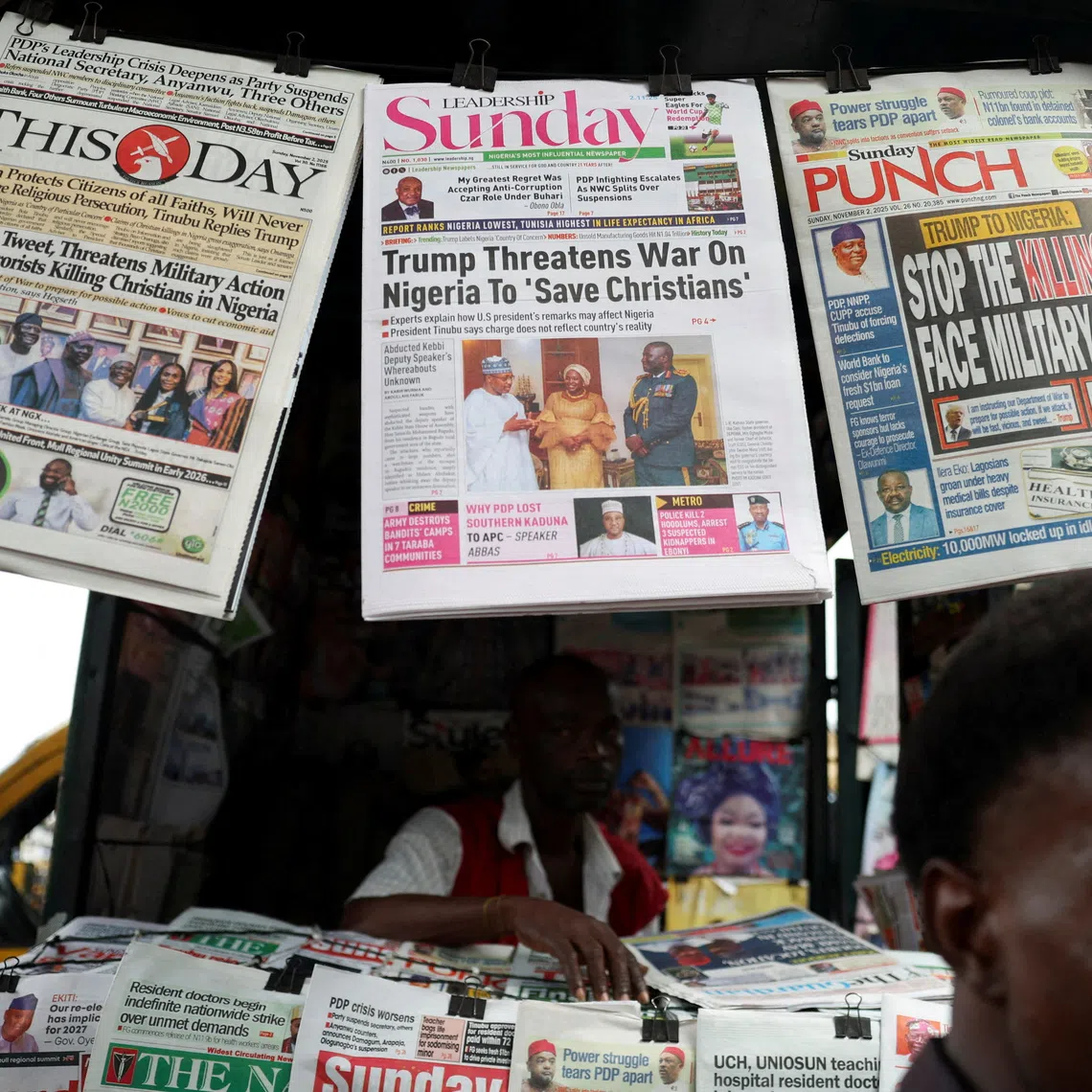 FILE PHOTO: Newspapers with articles reporting U.S. President Donald Trump's message to Nigeria over the treatment of Christians hang at a newspaper stand in Ojuelegba, Lagos, Nigeria November 2, 2025. REUTERS/Sodiq Adelakun/File Photo