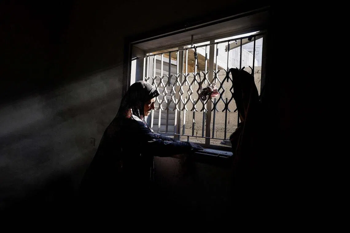 A Palestinian woman inspects the site of an Israeli strike on a house that was pre-warned by the Israeli military to evacuate before the strike was carried out late on Wednesday, in Al-Nuseirat refugee camp, in the central Gaza Strip, July 16, 2026. REUTERS/Mahmoud Issa TPX IMAGES OF THE DAY