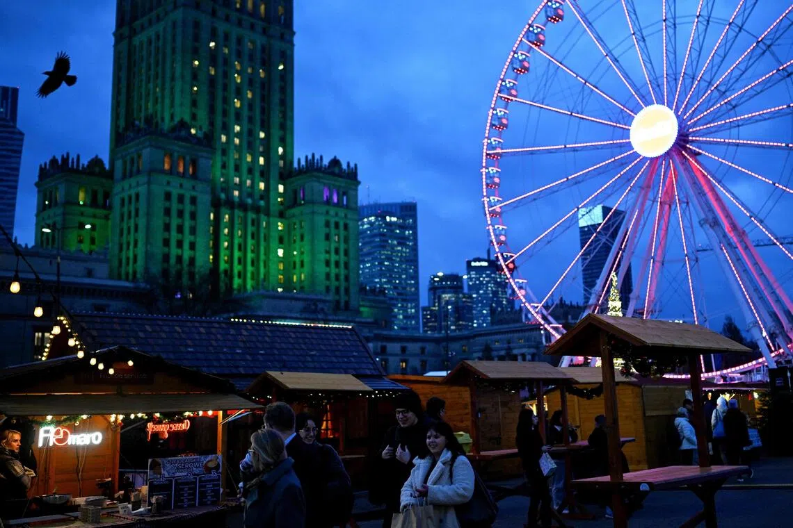 People visit the Christmas market in front of the Palace of Culture and Science in Warsaw.