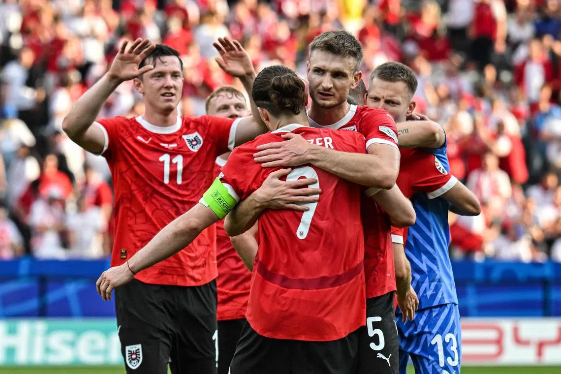 Austria's players celebrate after winning the match.