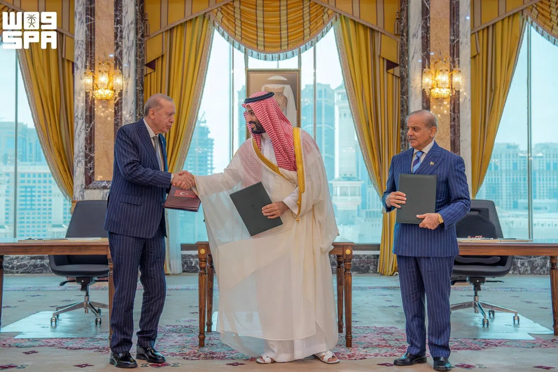 Turkish President Tayyip Erdogan shakes hands with Saudi Crown Prince Mohammed bin Salman, next to Pakistan’s Prime Minister Shehbaz Sharif, after signing a joint defence agreement in Mecca, Saudi Arabia, on Aug 7.