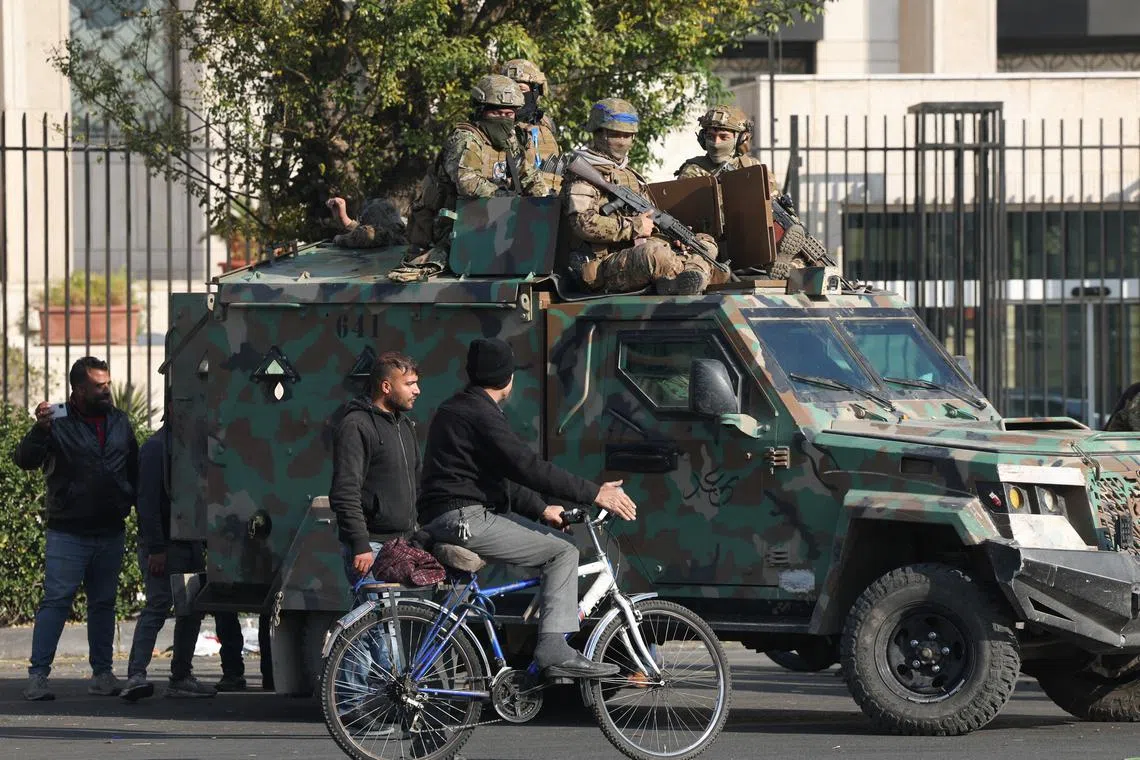 Rebel fighters sit on a vehicle, after rebels seized the capital and ousted President Bashar al-Assad, in Damascus, Syria, December 9, 2024. REUTERS/Mohamed Azakir
