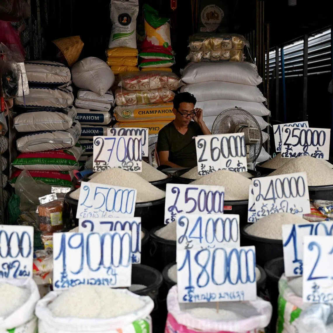 This photo taken on October 8, 2024 shows a rice vendor waiting for customers at his shop in Laos' capital Vientiane. Suffocating under a mountain of debt to China, communist Laos is struggling to tame rampant inflation, with food prices rising so sharply that a growing number of households are resorting to foraging.