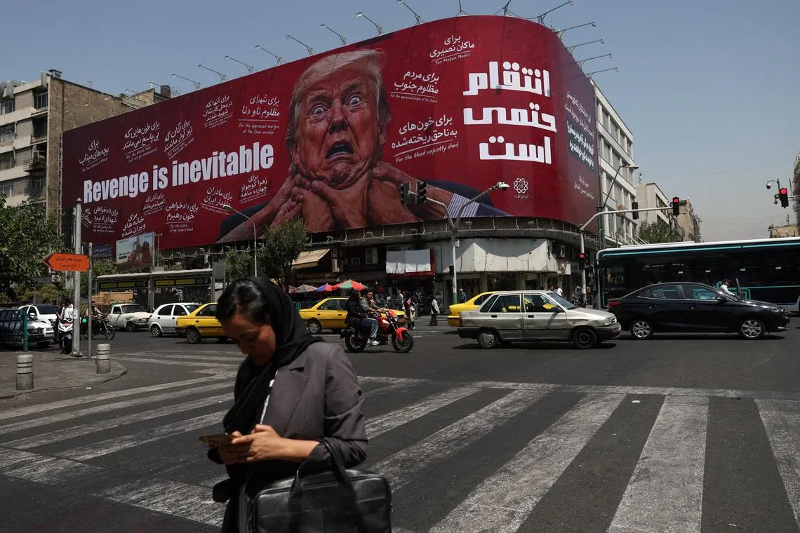 A woman walks near a billboard depicting U.S. President Donald Trump on a building in Tehran, Iran, July 27, 2026. Majid Asgaripour/WANA (West Asia News Agency) via REUTERS