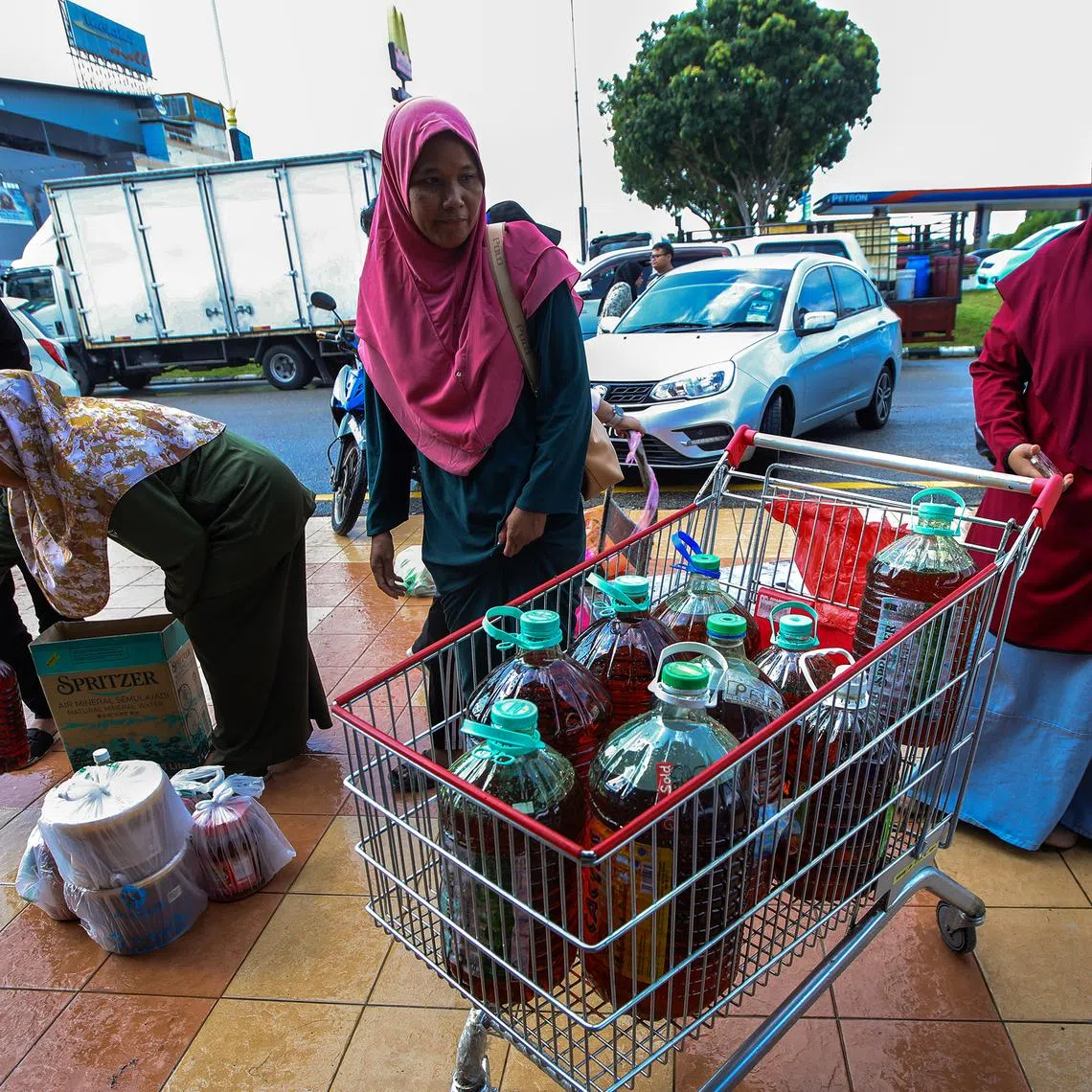 Members of the public delivering their used cooking oil to Evergreen Oil and Feed joint collection drive with the Melaka City Council. 