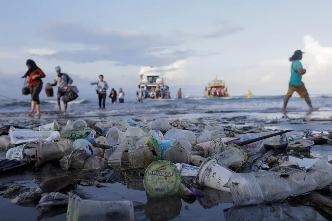 Tourists disembark a boat coming from nearby Nusa Penida island as plastic trash pollutes the beach in Sanur, Bali in this file picture. PHOTO: Reuters 