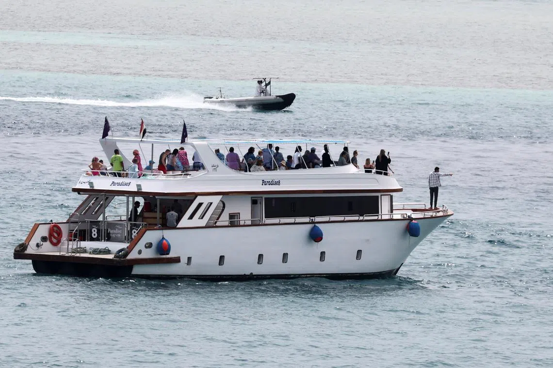 Tourists stand in a pleasure boat, after a tourist submarine sank off the Egyptian Red Sea resort city of Hurghada, Egypt, March 28, 2025. REUTERS/Mohamed Abd El Ghany