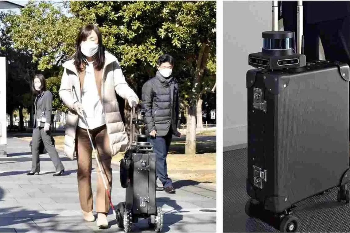 Researcher Chieko Asakawa walks with an AI-equipped suitcase she is developing in Koto Ward, Tokyo. 